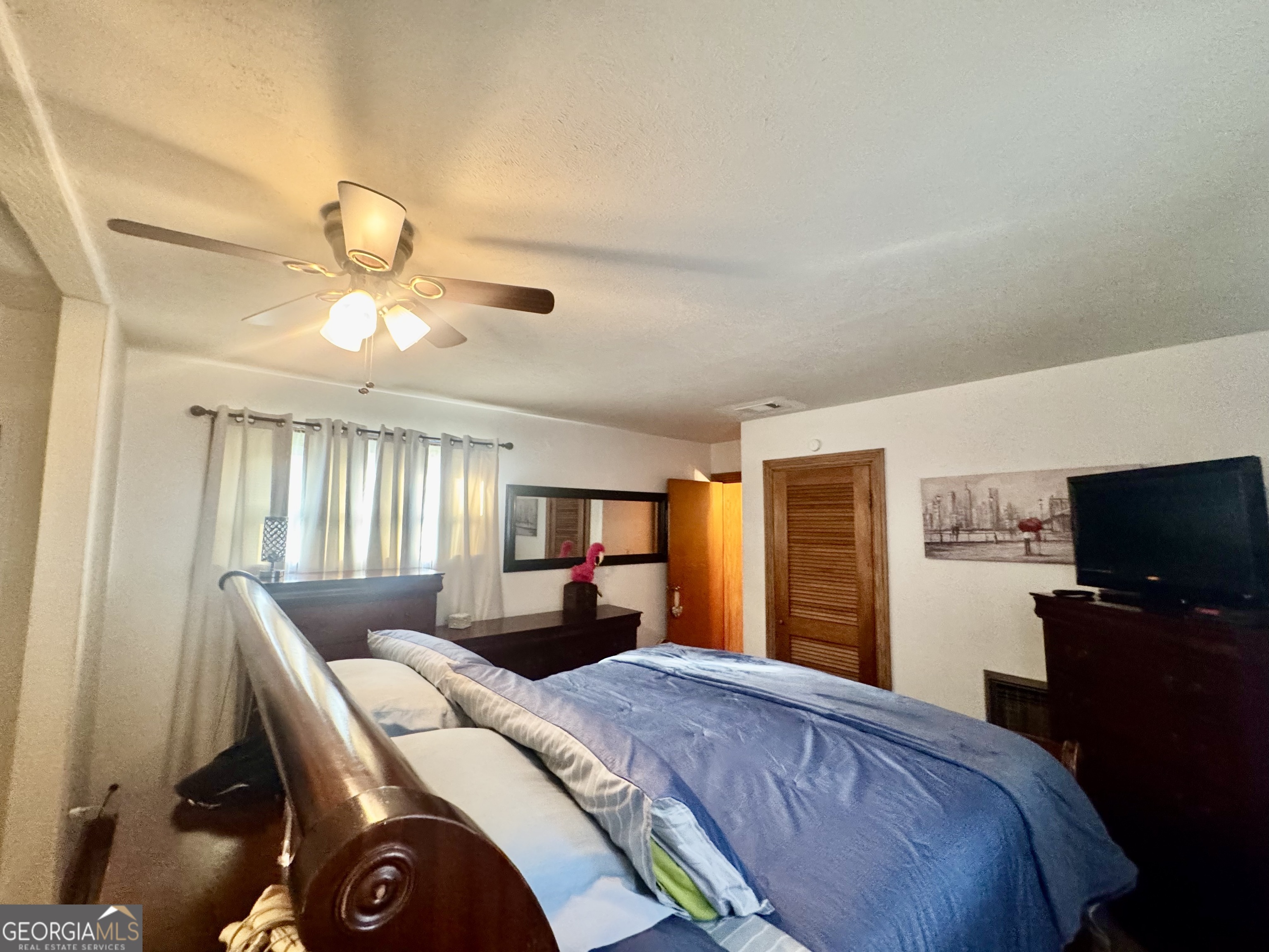 914 Adderton Street Americus, GA 31719 - Photo 30 of 54 a bedroom with a large bed and a flat screen tv