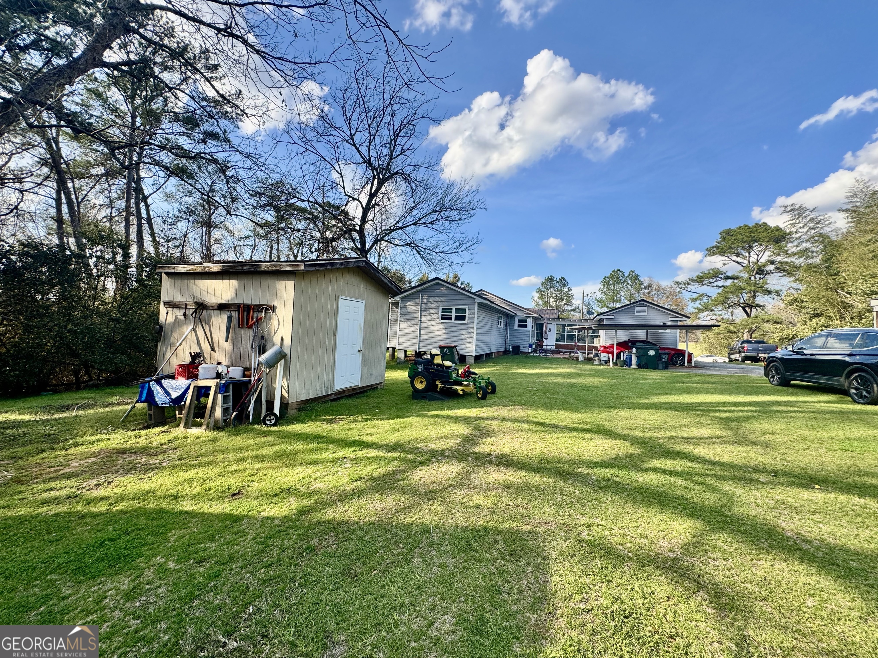 914 Adderton Street Americus, GA 31719 - Photo 9 of 54 a view of a house with a big yard and large trees