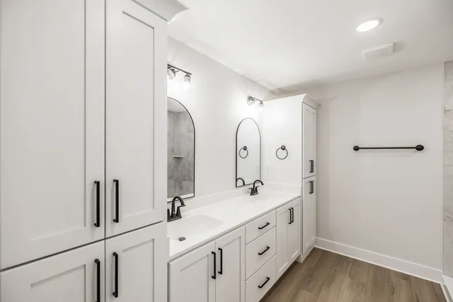 a spacious bathroom with a double vanity sink and mirror