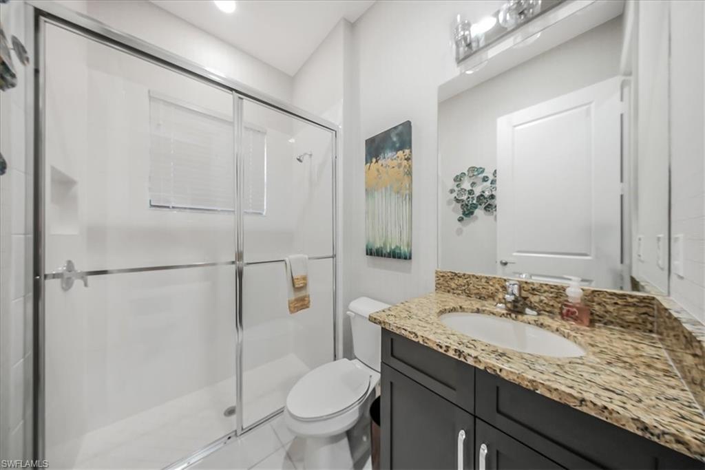 4036 Nova Lane Naples, FL 34119 - Photo 12 of 50 a bathroom with a granite countertop sink toilet and shower