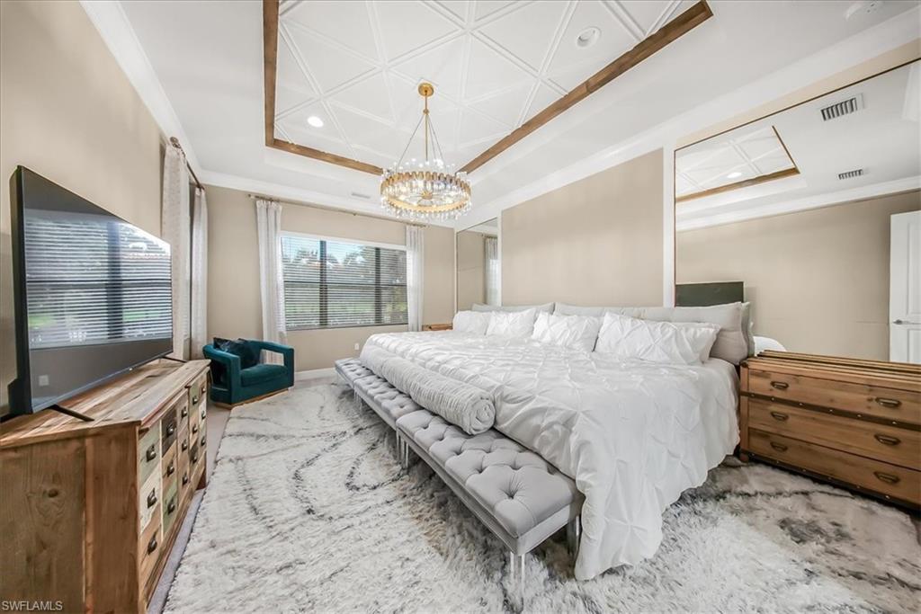 4036 Nova Lane Naples, FL 34119 - Photo 14 of 50 a bedroom with a large bed and a flat tv screen on dresser