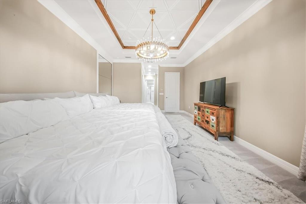 4036 Nova Lane Naples, FL 34119 - Photo 15 of 50 a spacious bedroom with a bed and a flat screen tv