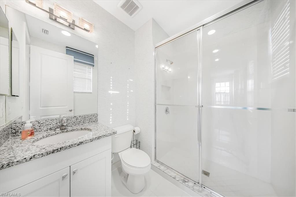 4036 Nova Lane Naples, FL 34119 - Photo 32 of 50 a bathroom with a granite countertop sink a toilet and shower