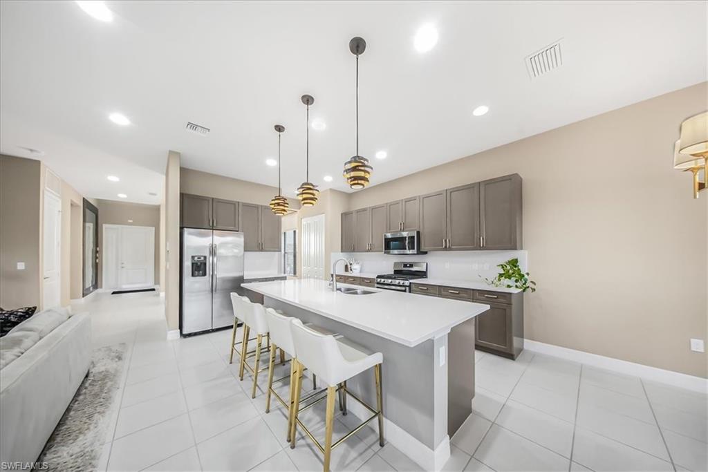 4036 Nova Lane Naples, FL 34119 - Photo 47 of 50 a kitchen with a sink a counter space appliances and cabinets