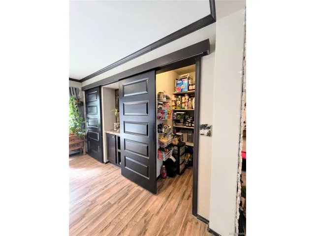 a view of a hallway with wooden floor and furniture
