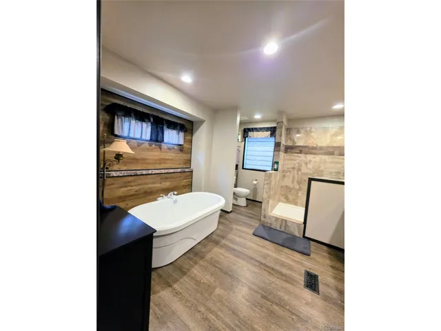a view of kitchen with stainless steel appliances kitchen island wooden cabinets and entryway