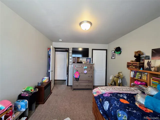 a bedroom with a large bed and a flat screen tv