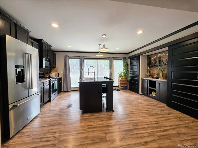 a kitchen with stainless steel appliances granite countertop a refrigerator and stove top oven