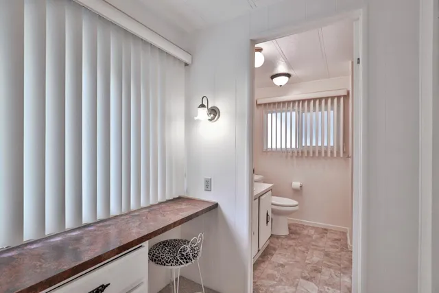 a bathroom with a granite countertop toilet and a sink
