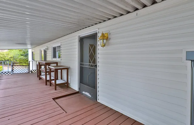 a living room with granite countertop furniture a flat screen tv and kitchen view