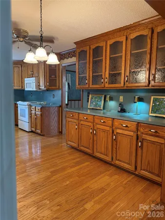 a kitchen with stainless steel appliances granite countertop a stove a sink and a wooden floors
