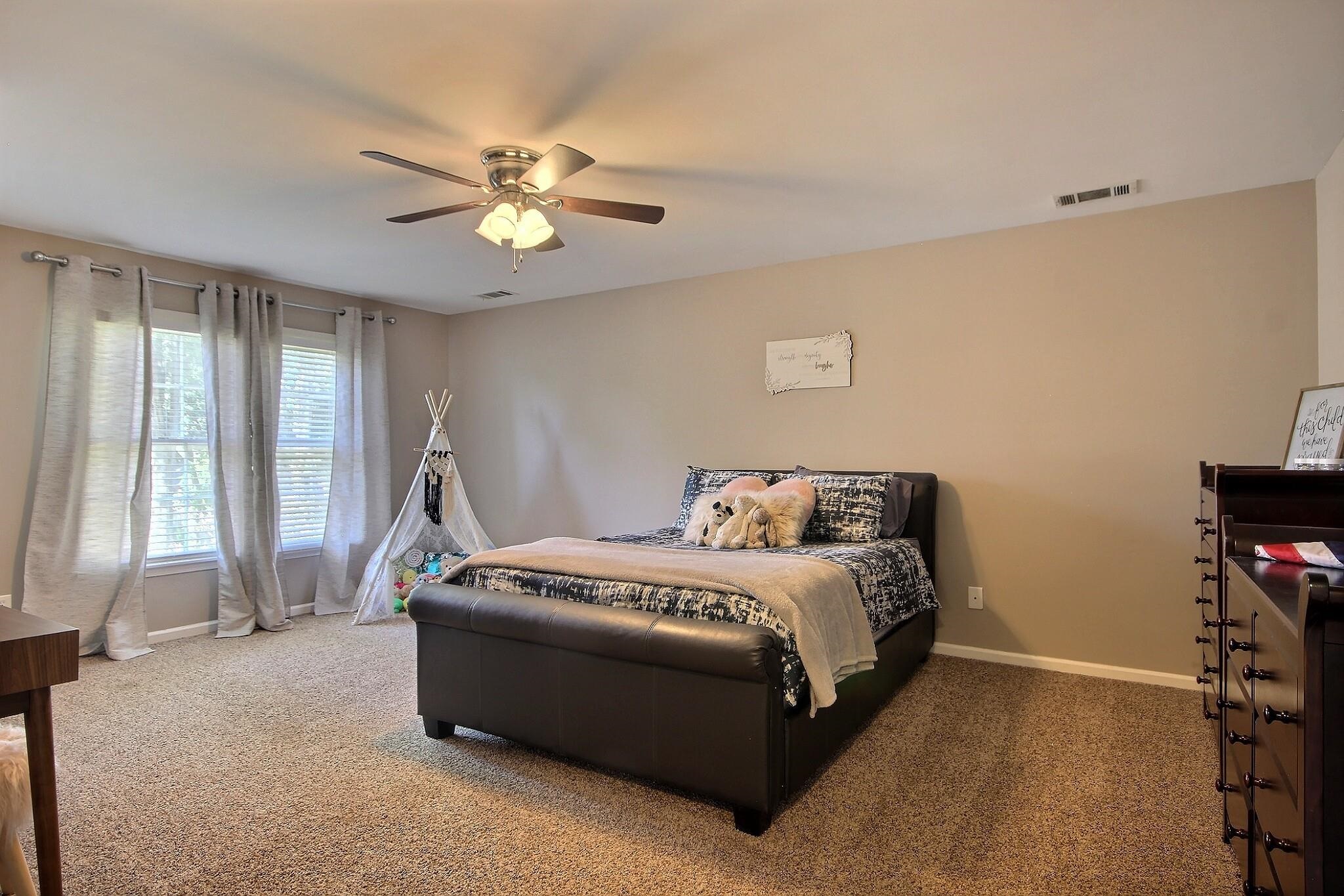 705 Cotham Drive Collierville, TN 38017 - Photo 19 of 25 a spacious bedroom with a bed and a chandelier