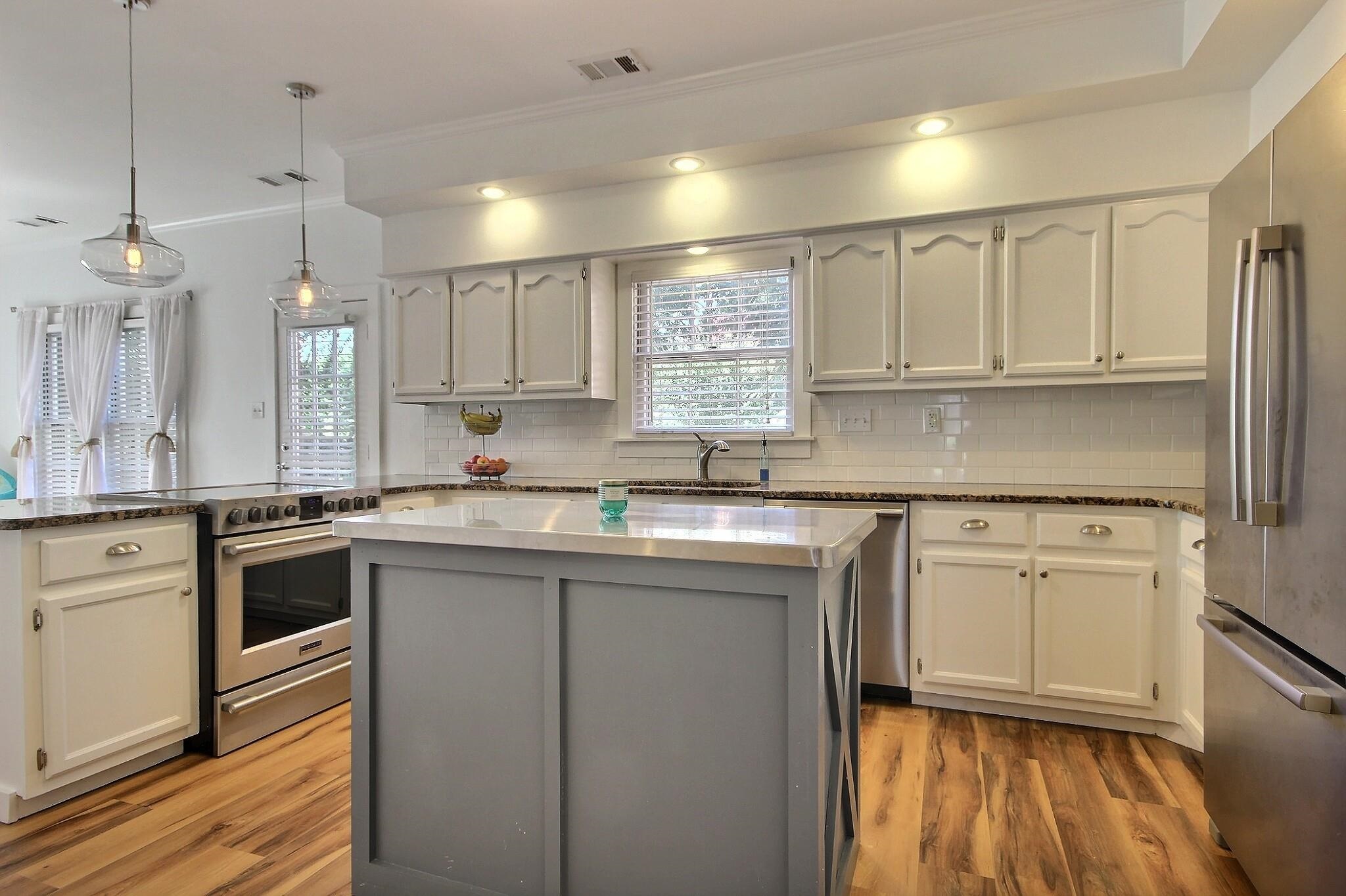 705 Cotham Drive Collierville, TN 38017 - Photo 3 of 25 a kitchen with kitchen island granite countertop white cabinets white appliances a sink and a window