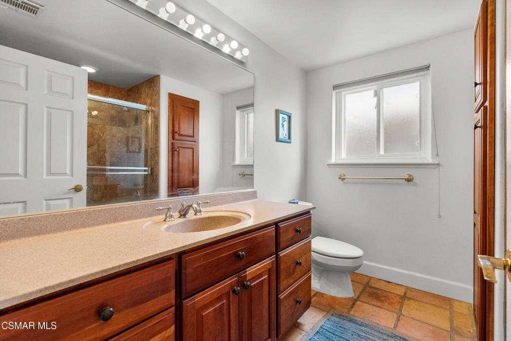 5138 Outrigger Way, Unit 1 Oxnard, CA 93035 - Photo 12 of 20 a bathroom with a granite countertop sink a toilet and a mirror