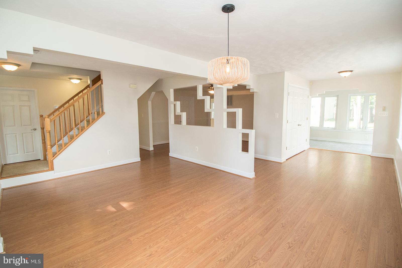 45044 Deagles Boatyard Road Tall Timbers, MD 20690 - Photo 20 of 64 a view of an empty room with wooden floor and a chandelier