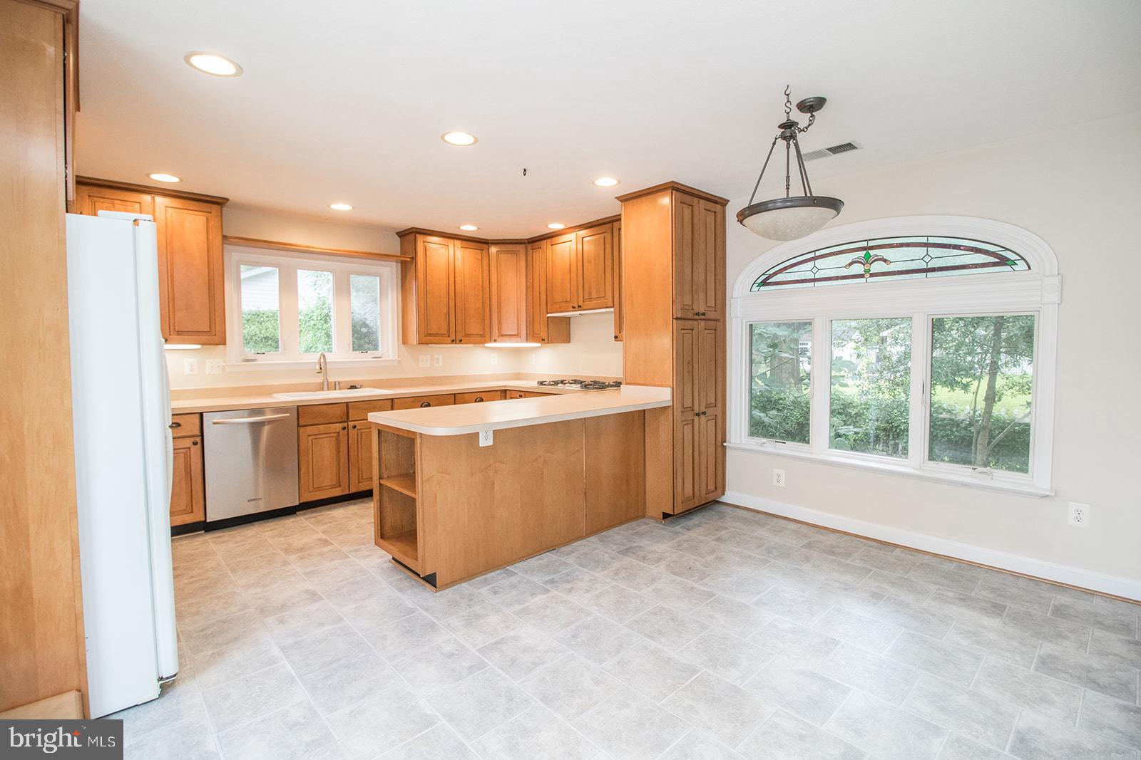 45044 Deagles Boatyard Road Tall Timbers, MD 20690 - Photo 27 of 64 a kitchen with stainless steel appliances granite countertop a stove a sink a refrigerator and white cabinets with wooden floor