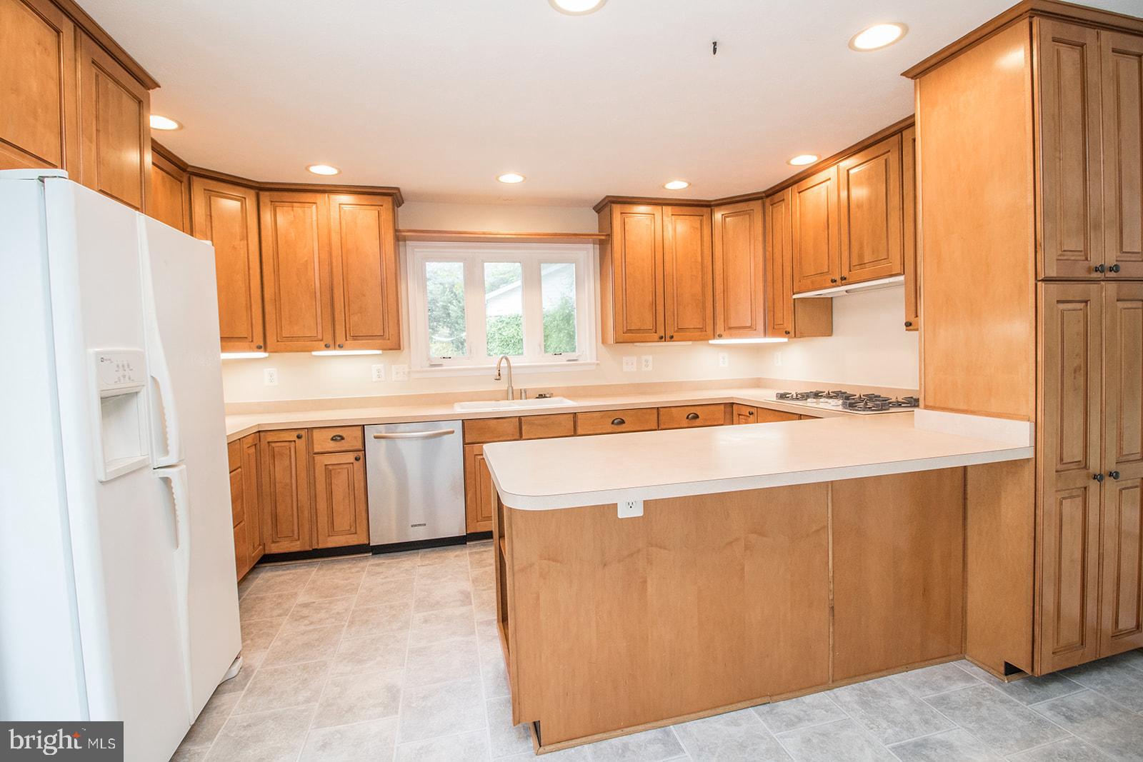 45044 Deagles Boatyard Road Tall Timbers, MD 20690 - Photo 28 of 64 a kitchen with stainless steel appliances granite countertop a refrigerator a sink dishwasher a stove and white countertops with wooden floor