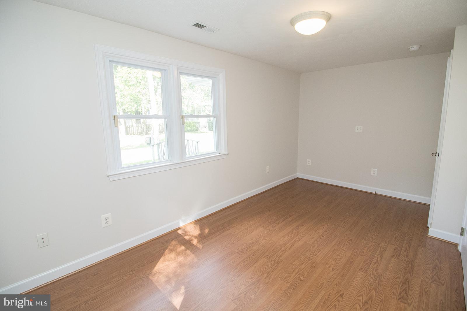 45044 Deagles Boatyard Road Tall Timbers, MD 20690 - Photo 35 of 64 an empty room with wooden floor and windows
