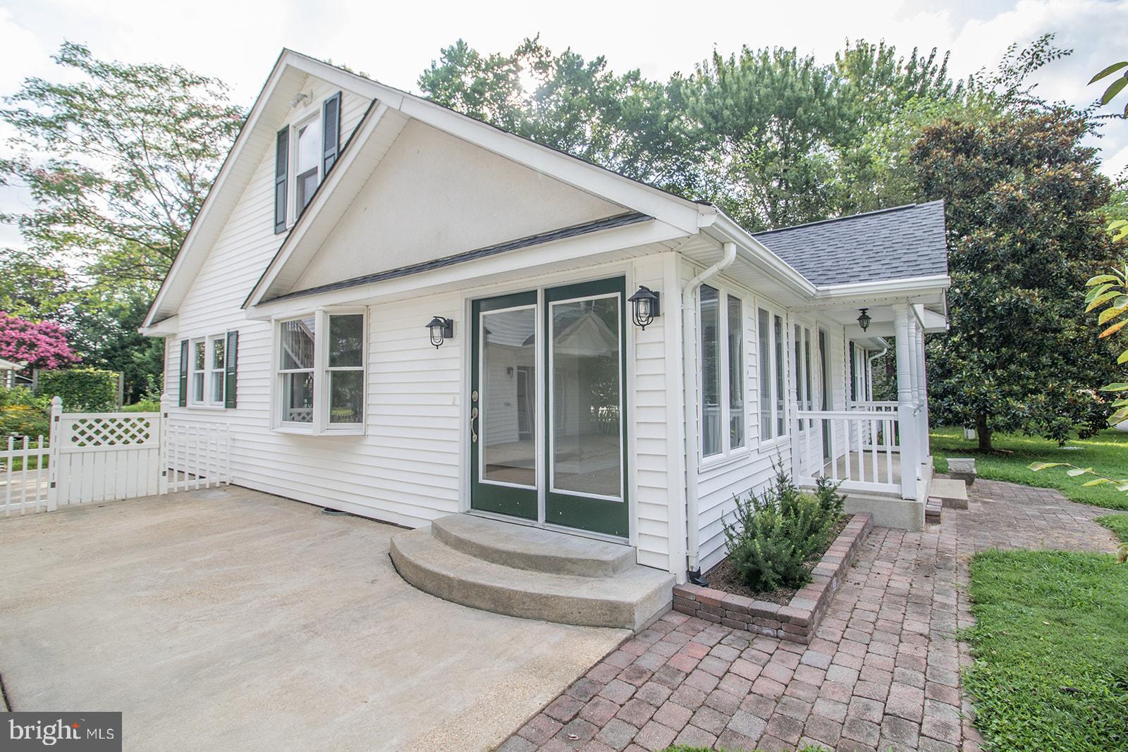 45044 Deagles Boatyard Road Tall Timbers, MD 20690 - Photo 4 of 64 a view of a white house with a small yard plants and a large tree
