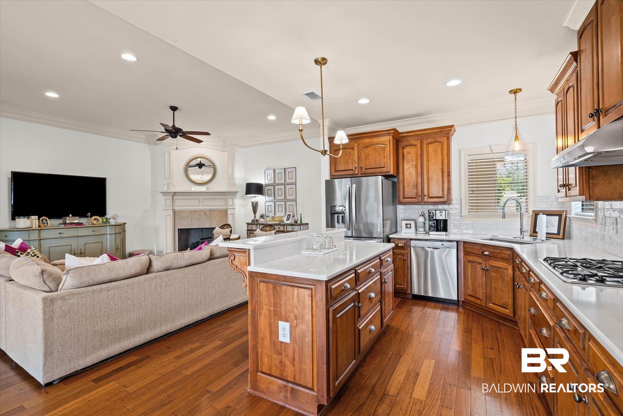 3459 Rue Royal Mobile, AL 36693 - Photo 8 of 31 Open-concept kitchen featuring wood cabinetry, stainless steel appliances, white subway tile backsplash, and a central island with a white countertop