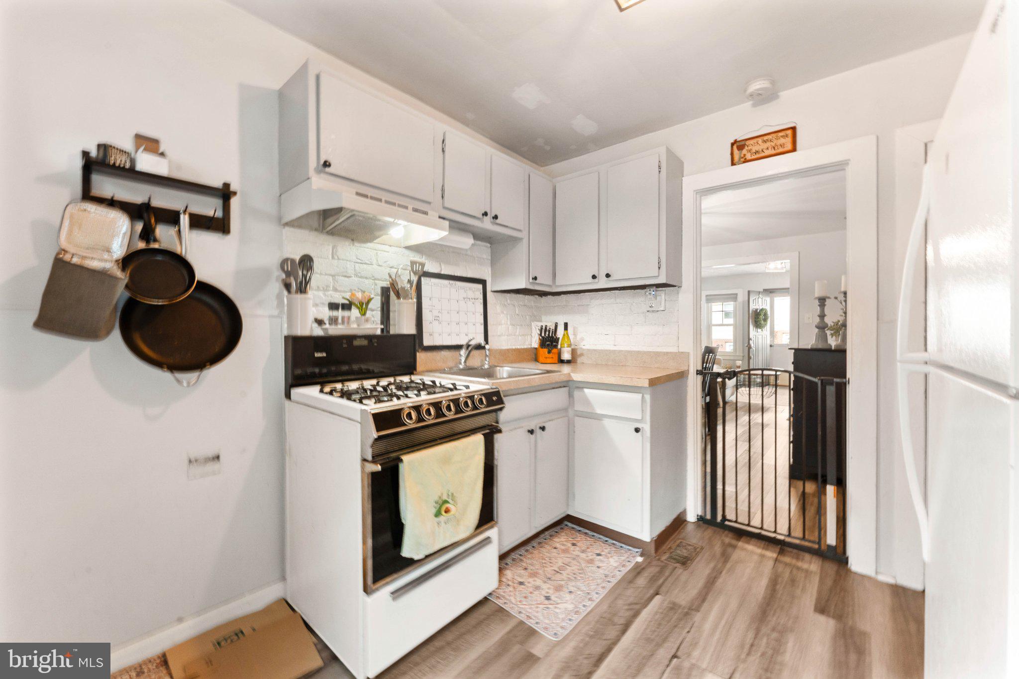 4823 Tibben Street Philadelphia, PA 19128 - Photo 12 of 28 a kitchen with a stove cabinets and a window