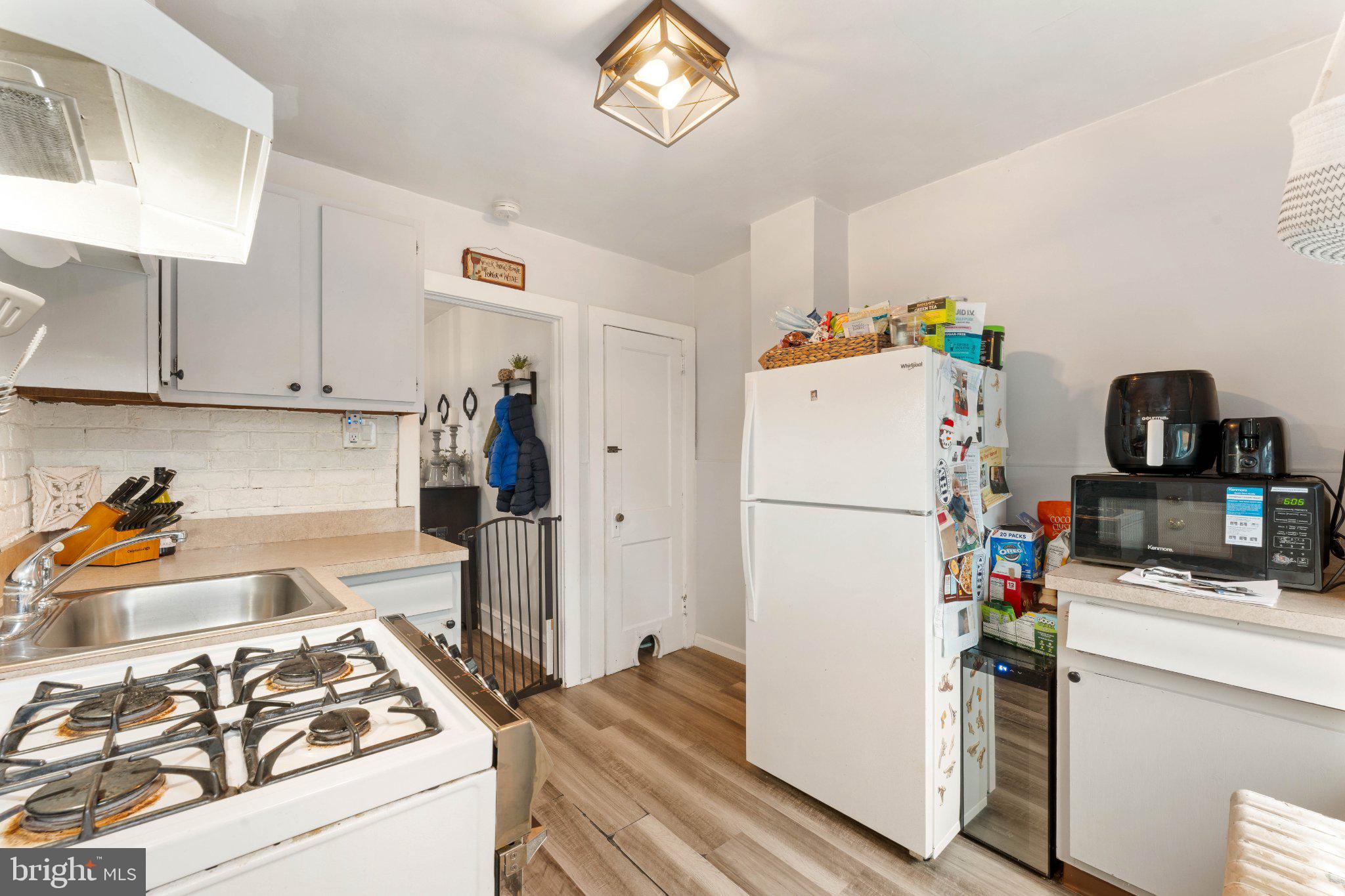 4823 Tibben Street Philadelphia, PA 19128 - Photo 14 of 28 a kitchen with a refrigerator and a stove top oven