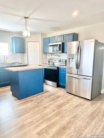 a kitchen with stainless steel appliances kitchen island granite countertop a stove and a refrigerator
