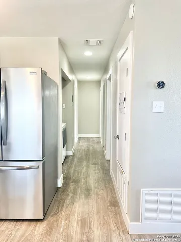 a view of a hallway with wooden floor