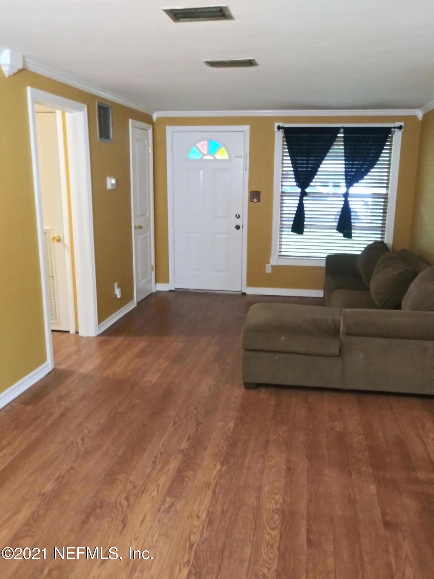 4245 Springwood Road Jacksonville, FL 32207 - Photo 3 of 12 a living room with a couch and a table with wooden floor