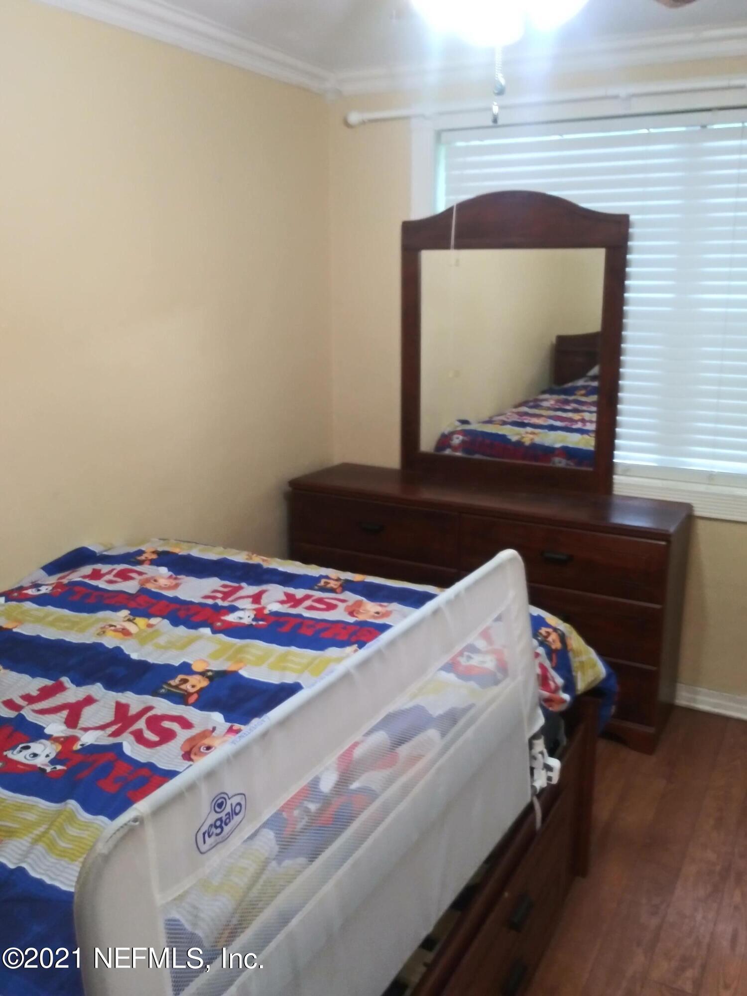 4245 Springwood Road Jacksonville, FL 32207 - Photo 7 of 12 a bedroom with a bed and a flat screen tv