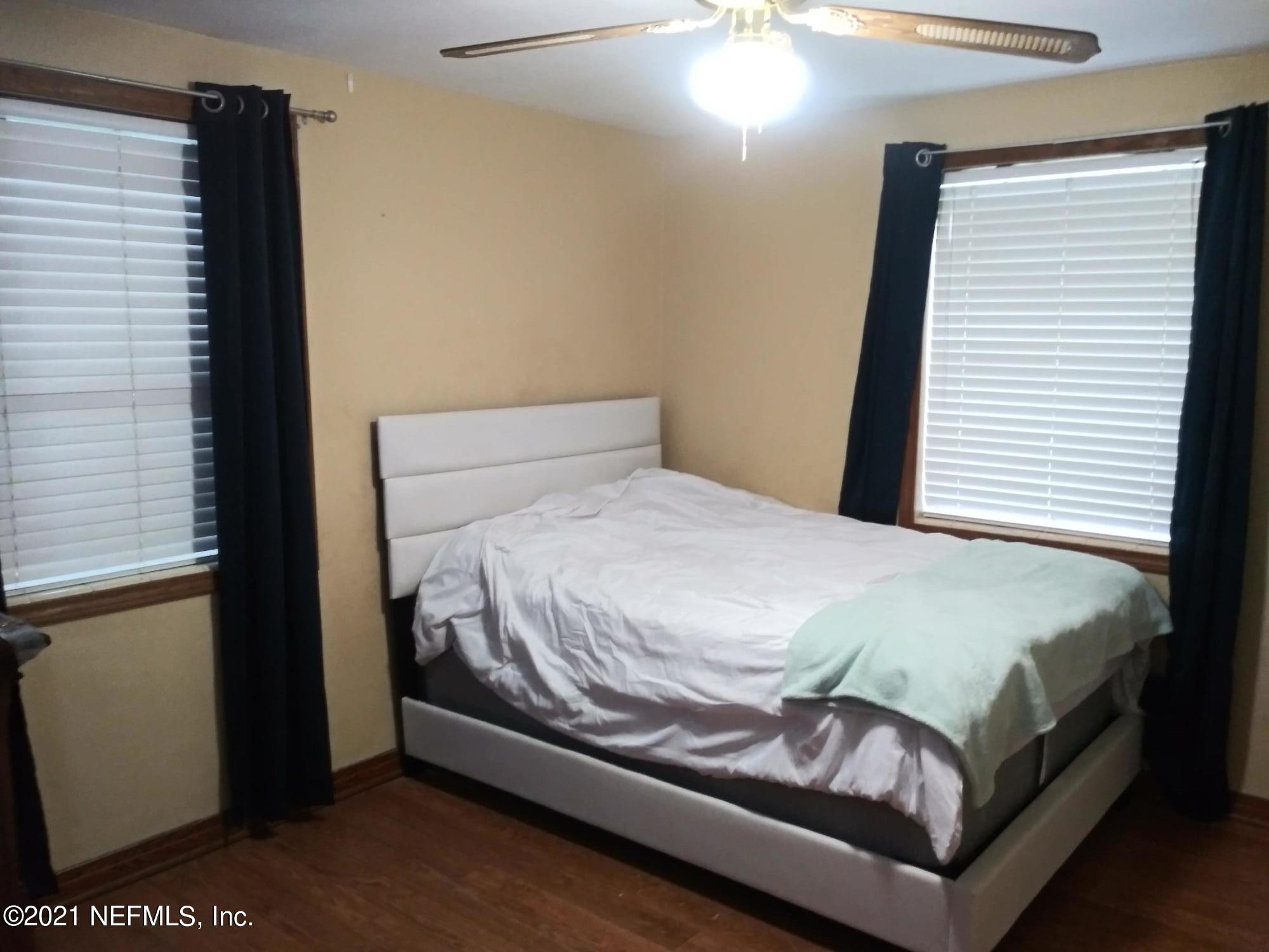 4245 Springwood Road Jacksonville, FL 32207 - Photo 8 of 12 a bed sitting in a bedroom next to a window