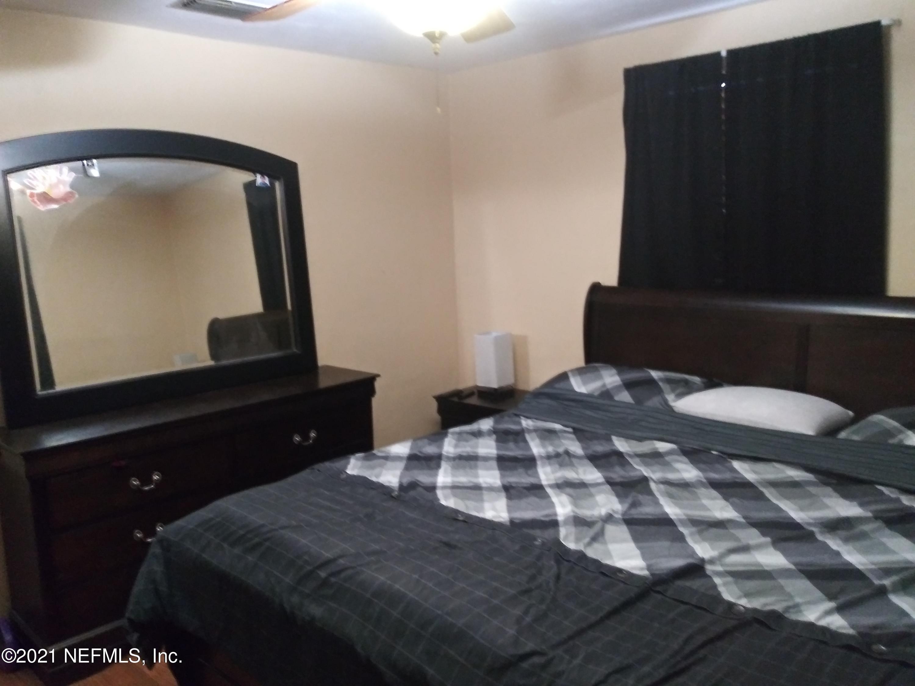 4245 Springwood Road Jacksonville, FL 32207 - Photo 9 of 12 a bedroom with a bed and a mirror on dresser