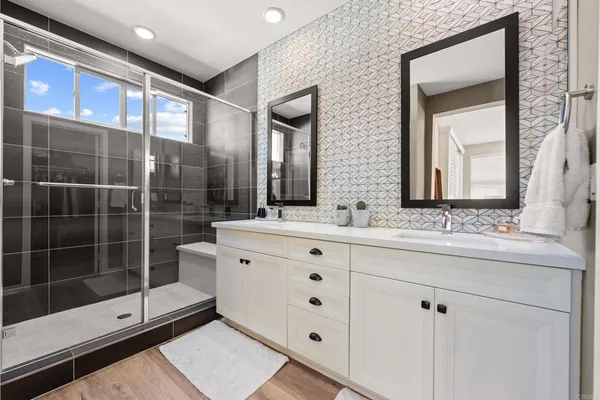 a bathroom with a double vanity sink mirror and shower