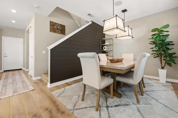 a dining room with furniture potted plants and wooden floor