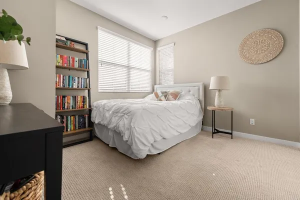 a bedroom with a bed bookshelf and a window