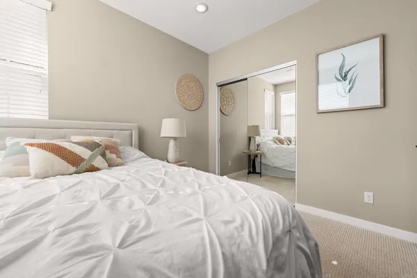 a bedroom with a bed and painting on the wall