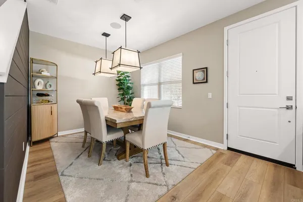 a dining room with furniture a chandelier and wooden floor