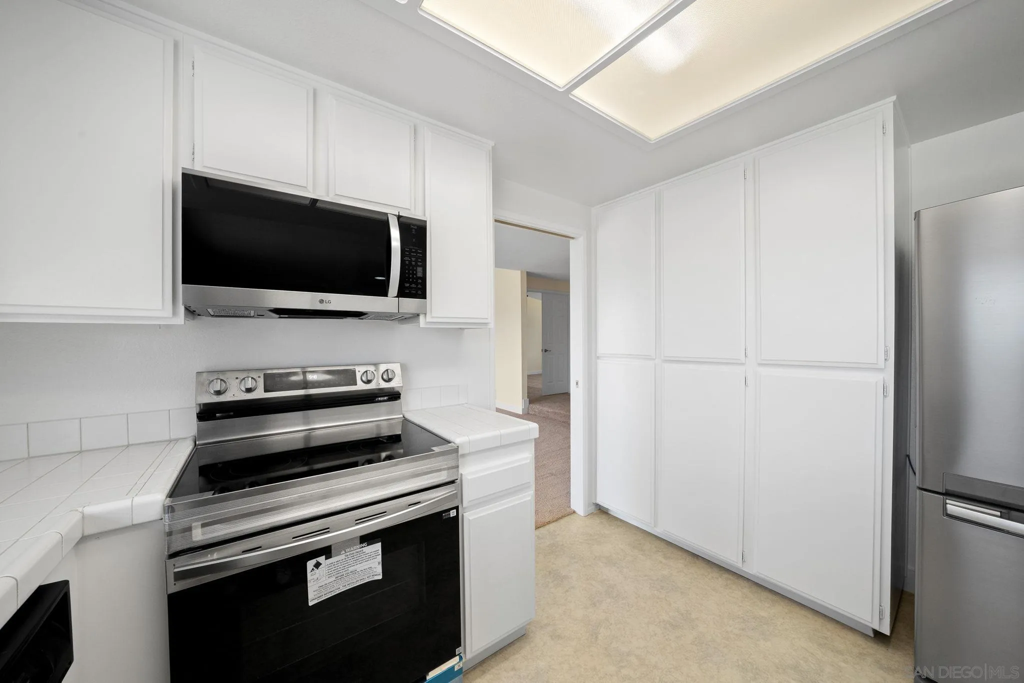 11004 Del Rio Road Spring Valley, CA 91978 - Photo 16 of 51 a view of kitchen with a microwave and a refrigerator