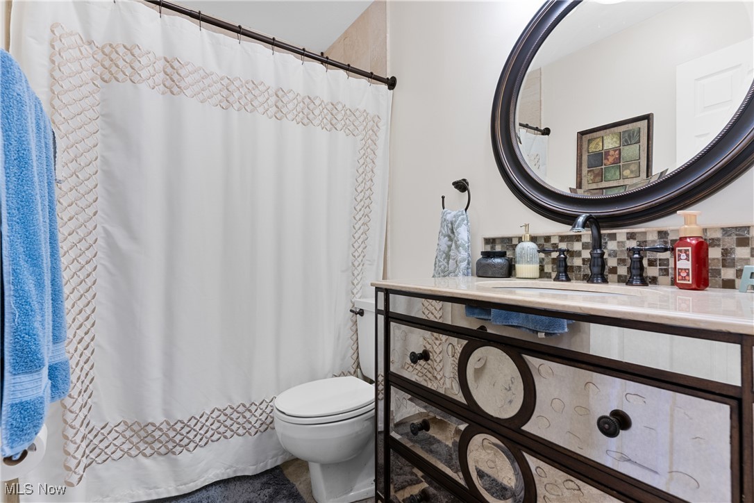 9105 Valley View Road Macedonia, OH 44056 - Photo 24 of 41 Bathroom with vanity, decorative backsplash, and a shower with curtain