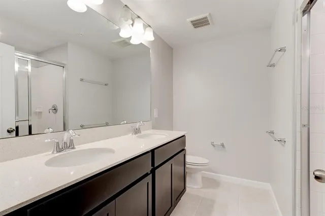 a bathroom with a sink a toilet a light fixture and a mirror