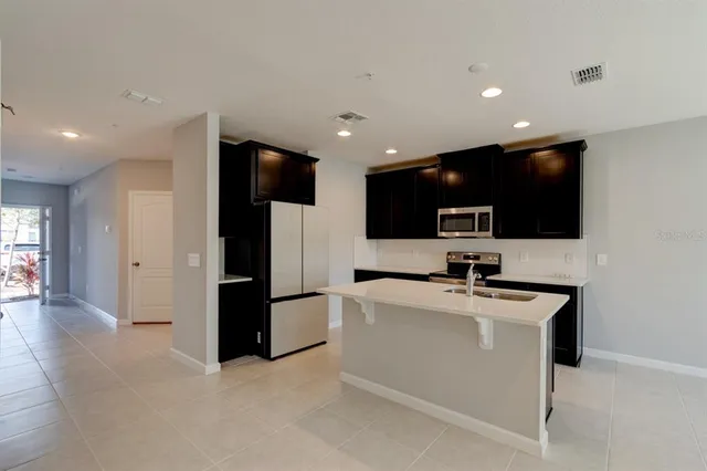 a kitchen with stainless steel appliances a refrigerator sink and microwave