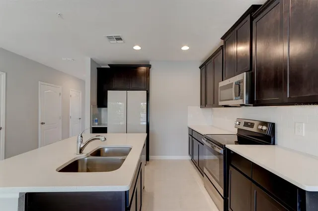 a kitchen with granite countertop a sink and a refrigerator