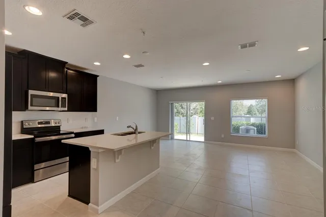 a kitchen with a sink stainless steel appliances and cabinets
