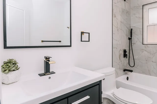 a bathroom with a sink a toilet and shower