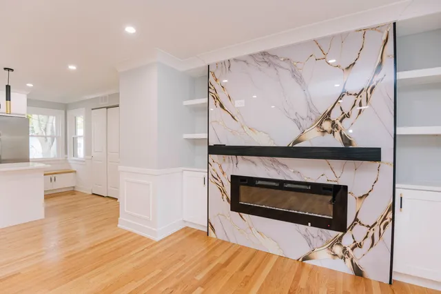 a living room with wooden floor and a fireplace