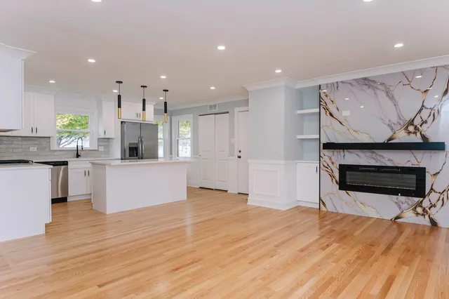 a view of kitchen with kitchen island microwave and cabinets