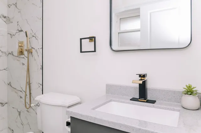 a bathroom with a toilet sink and mirror