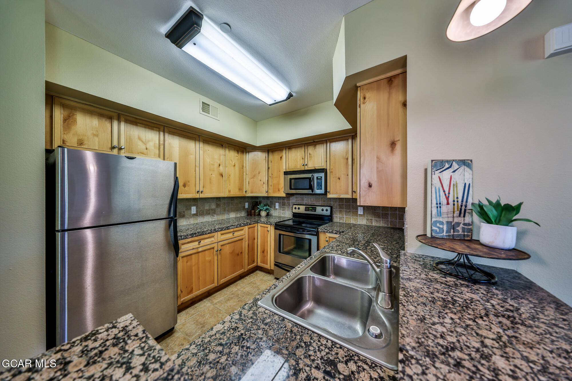 175 Gcr 8340, Unit 1 Fraser, CO 80442 - Photo 8 of 28 a kitchen with a refrigerator a sink stainless steel appliances and cabinets