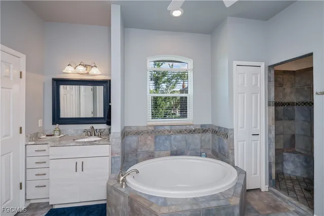 a en suite bathroom with a granite countertop sink and a mirror