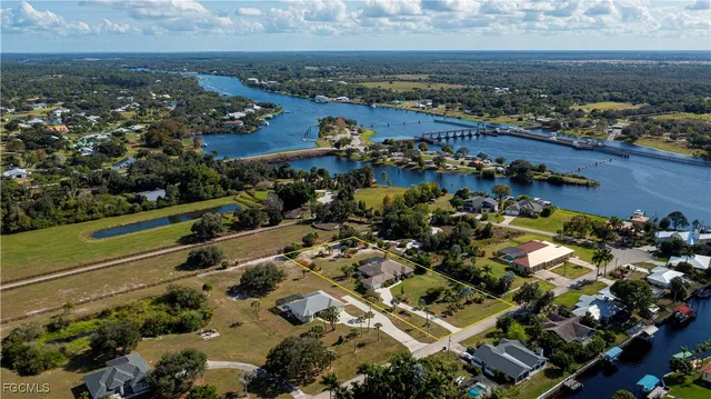 an aerial view of a city with lots of residential buildings ocean and mountain view in back